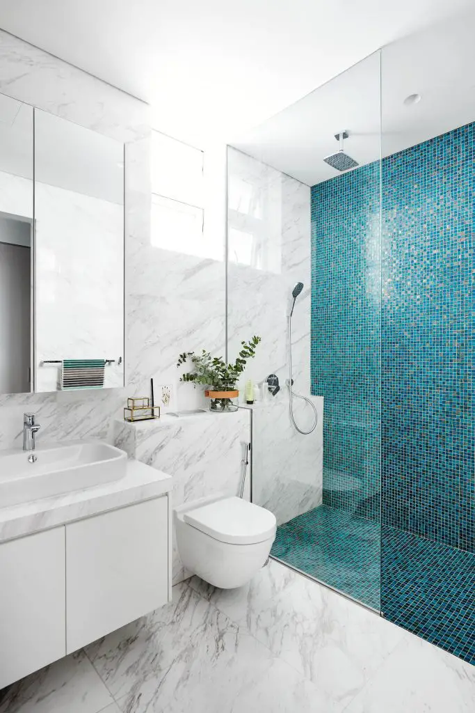 Example of a trendy blue tile, white tile and mosaic tile marble floor walk in shower design in Singapore with flat panel cabinets, white cabinets, a wall mount toilet and a vessel sink
