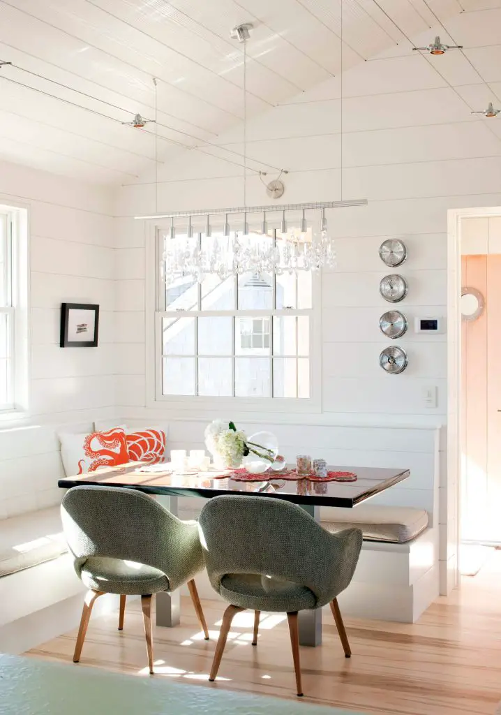 The tweed covered Saarinen armchair adds warmth and color to the all white breakfast banquette in this Philadelphia kitchen