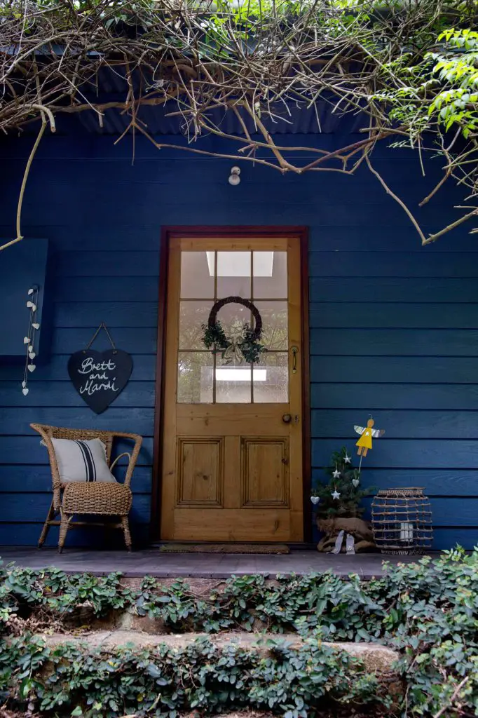 A tree topped with a sweet yellow angel spreads the holiday spirit on this front porch in Australia.
