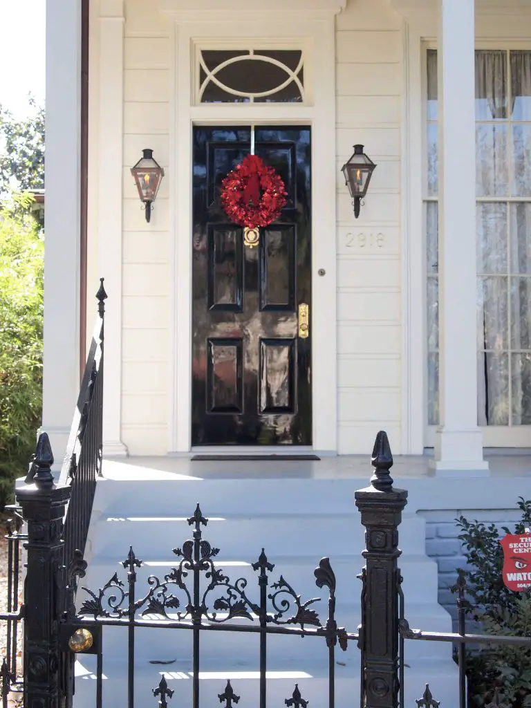 An all red wreath is a standout against a classic black and white New Orleans home.