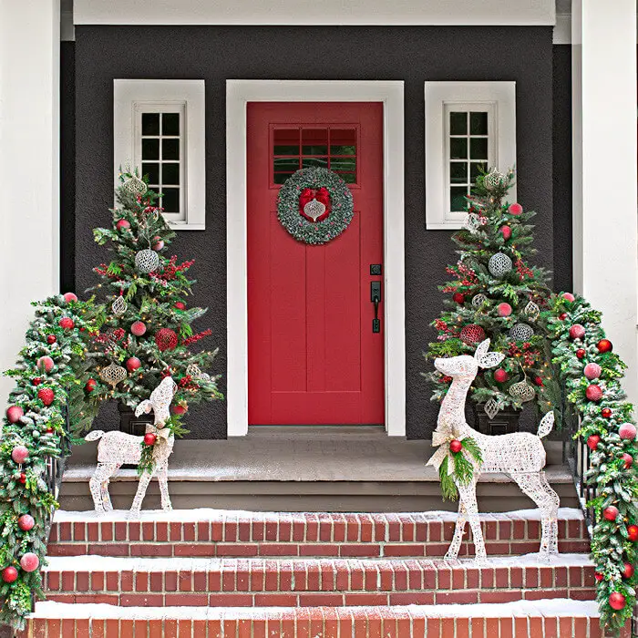 Happy reindeer and substantial garlands welcome at this front door, which is painted the perfect shade of red for the season.