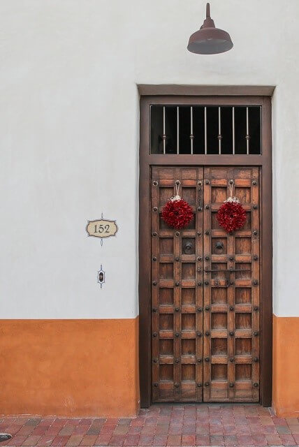 Wreaths made of red chilis feel right at home on these Tuscan doors.